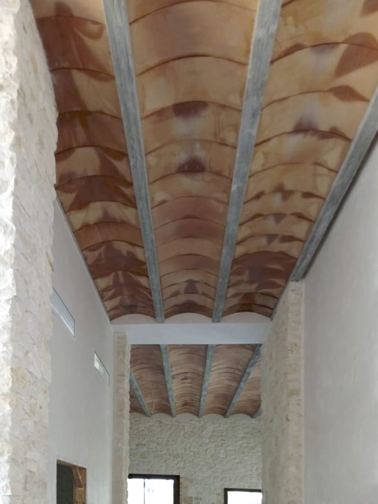 Imagen de un pasillo con vigas vistas de hormigón imitación madera, durante la obra.