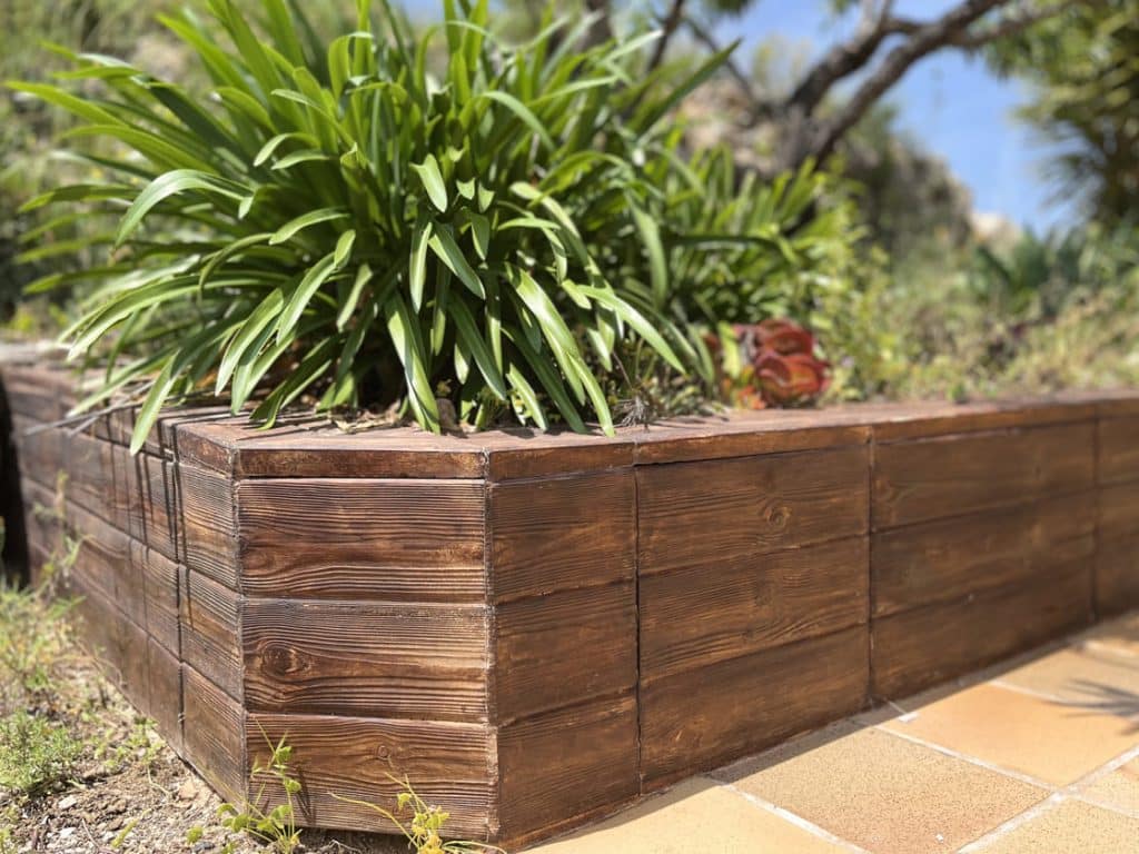Jardinera con tablones de hormigón imitación madera.