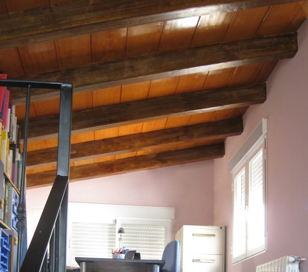Buhardilla con forjado con vigas imitación madera.
