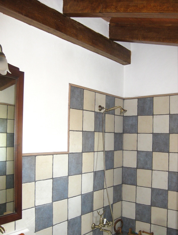 Baño con forjado con vigas imitación madera abuhardillado.