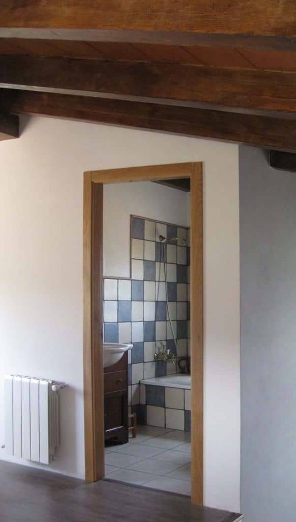Descansillo de una vivienda con forjado con vigas imitación madera.
