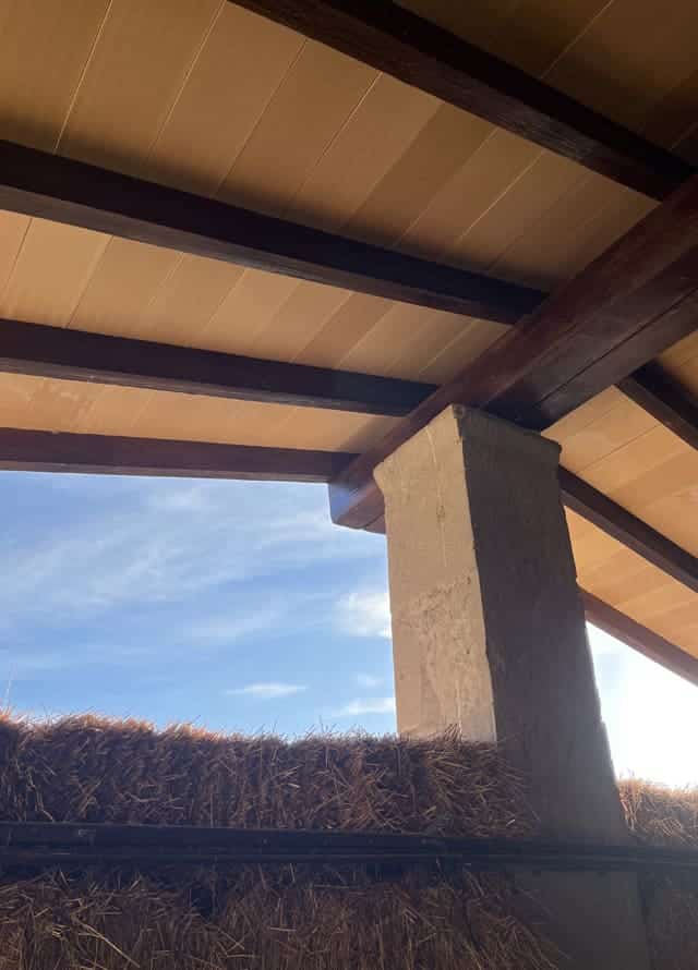 Granero de construcción rústica con vigas de hormigón imitación madera.